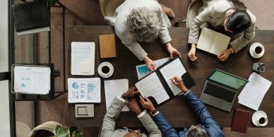 Business team meeting with documents and a laptop