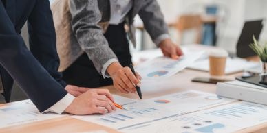 Two professionals analyzing charts and graphs at a desk