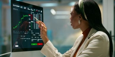 Analyst reviewing stock market data on a large screen